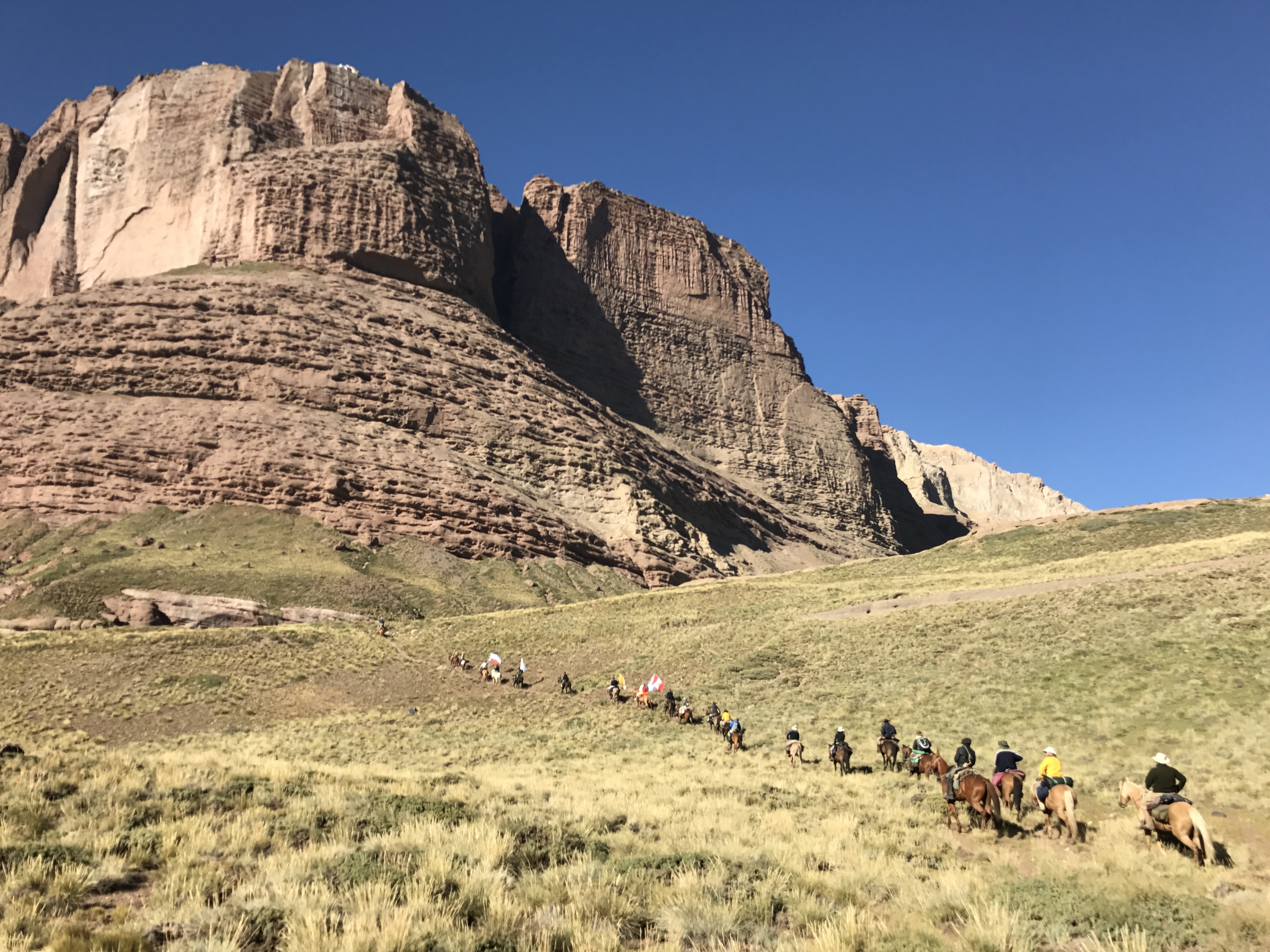 Caravana bajo la imponente formación geológica estratificada
