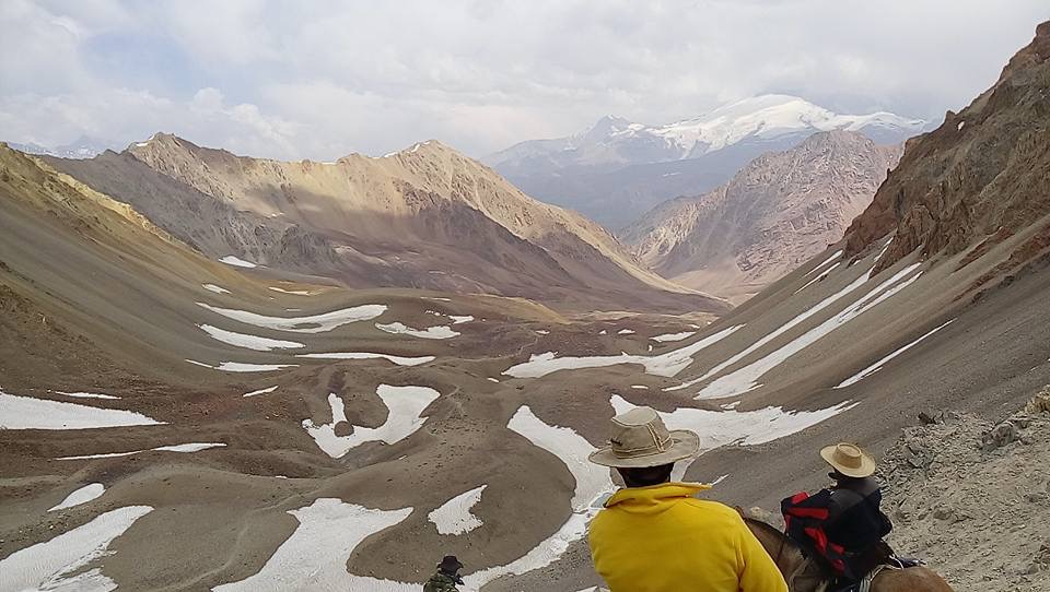 Vista panorámica desde la cumbre con jinetes observando el valle serpenteante