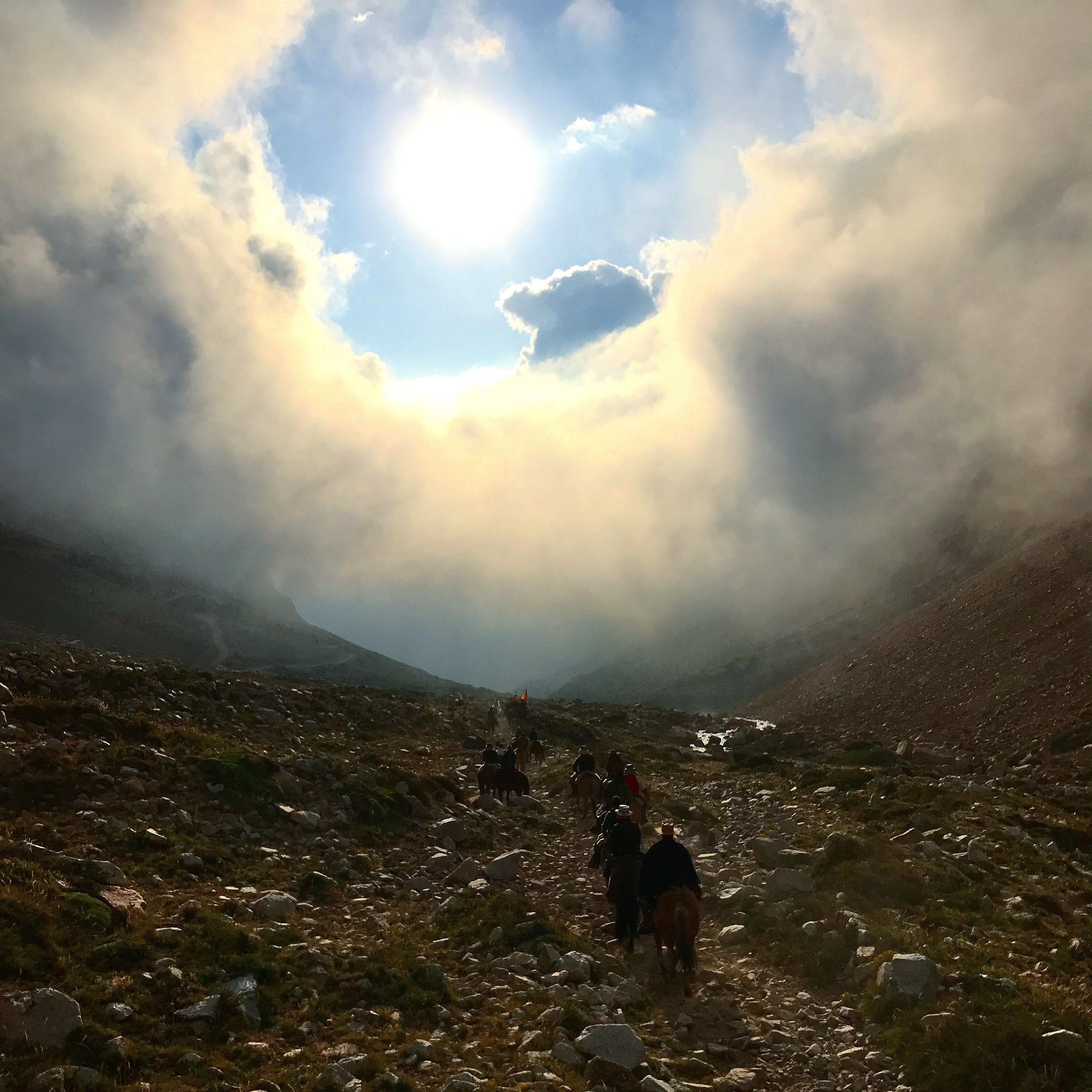 Momento dramático con rayos de sol atravesando las nubes sobre la expedición