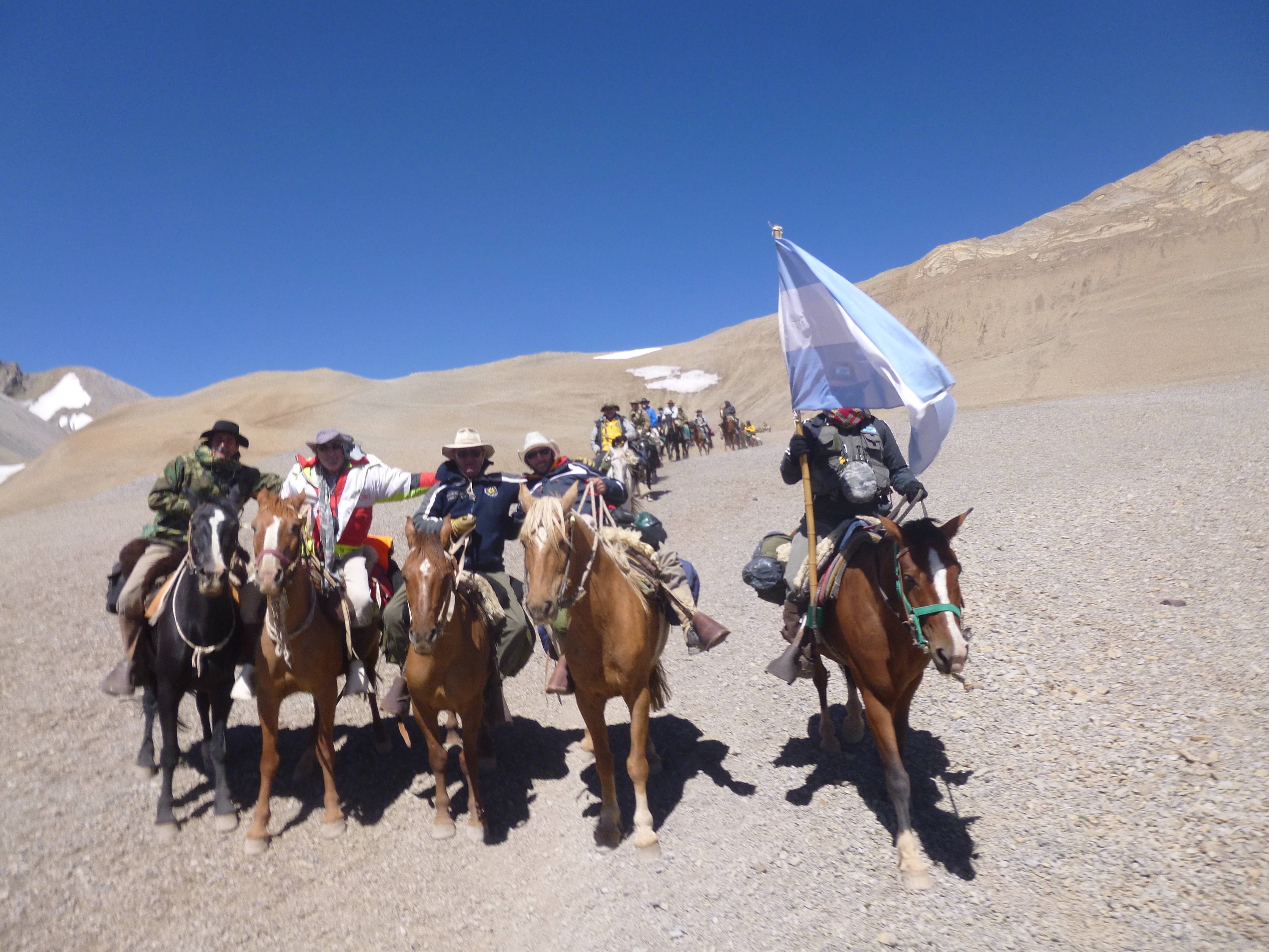 Expedicionarios con trajes de época y bandera argentina en la cordillera